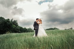 Bride And Groom Embracing In Field Good Shephard Church In Colleyville
